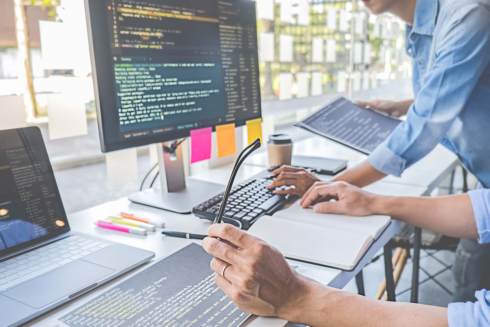 two men looking at code and analytics on a computer screen