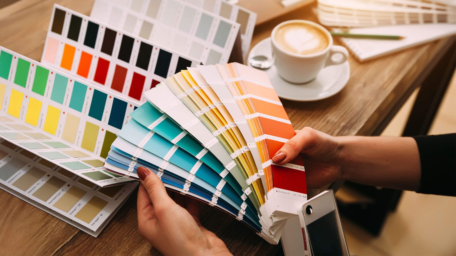 a person holding a color book and sifting through multiple different colors