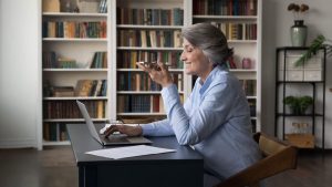 an old woman smiling at her computer while on a call