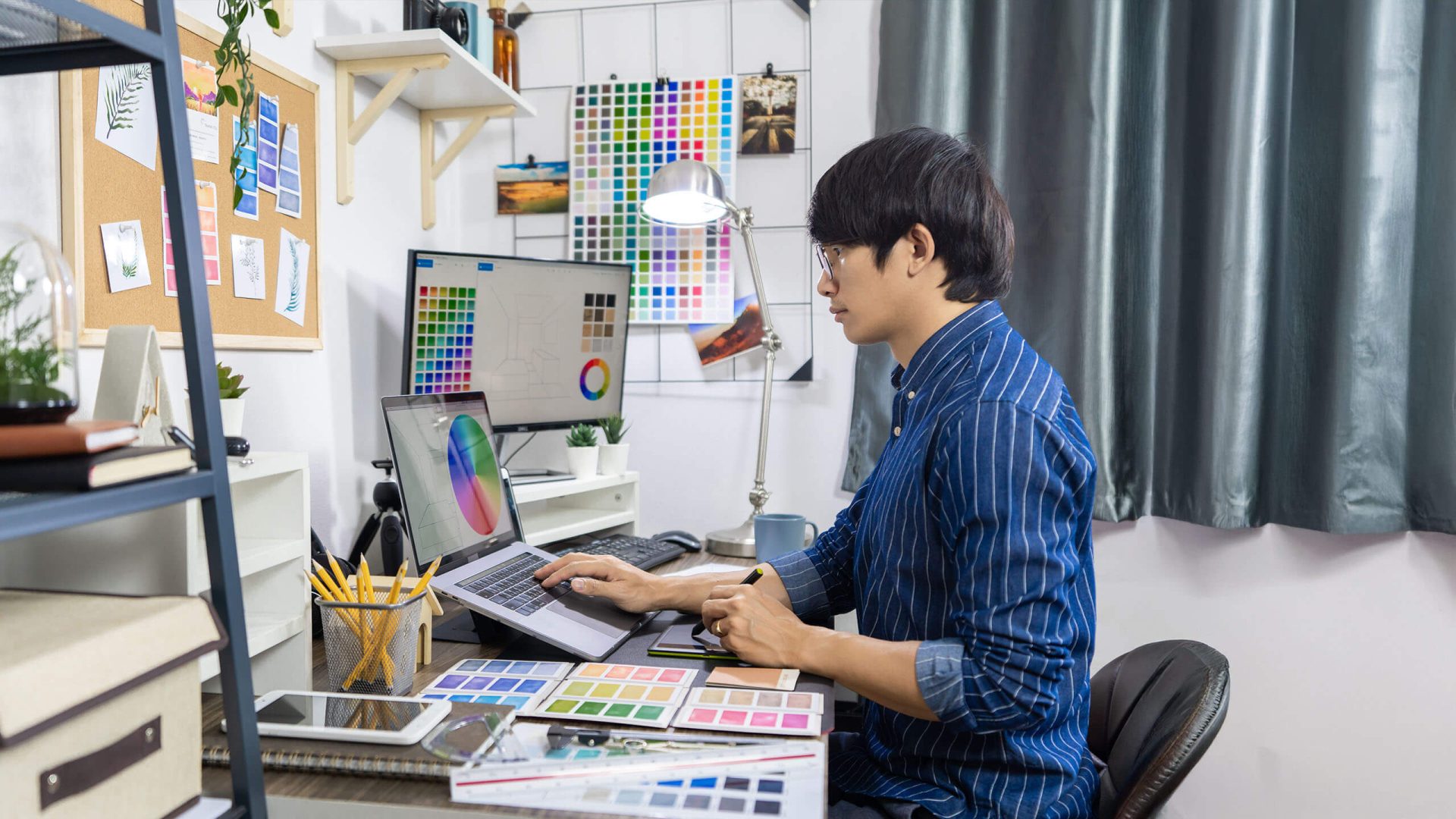 a man sitting at his desk observing different color variations for a project