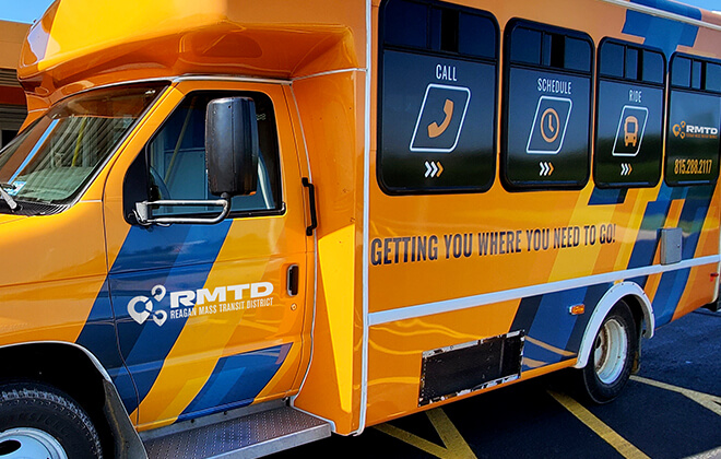 Brightly branded van wraps and signage for a transportation company